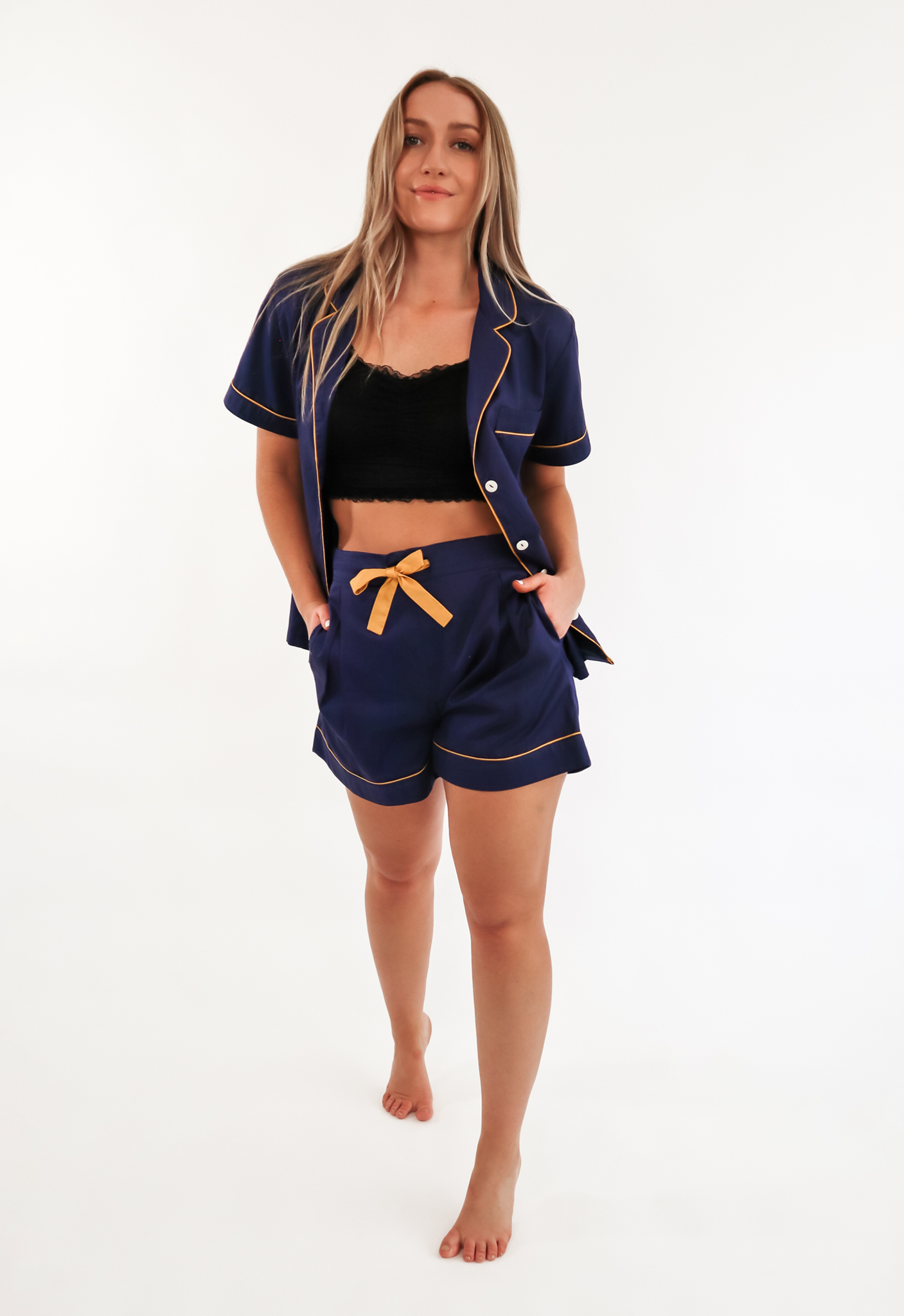 Short navy and yellow pyjama set with top unbuttoned to show black lace bralette.